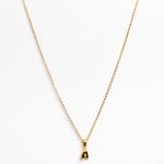 Gold necklace with a small pendant on a white background